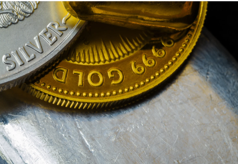 Close-up of 999 gold and silver bullion coins stacked together.